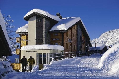 a ski lodge with people walking in the snow at Swiss Chalet-Style Hotel Walliser Spycher in Riederalp