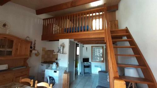 una cocina con una escalera que conduce a un loft en Mazet de vacances dans le Domaine de l'Espaï, en Saint-Martin-de-Brômes