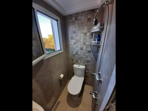 uma pequena casa de banho com um WC e uma janela em Jasmine Studio coquette em Nabeul