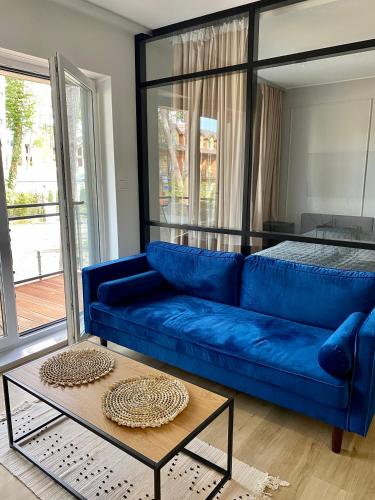 a blue couch in a living room with a table at Apartament LEA in Międzywodzie
