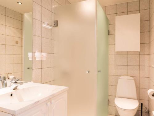La salle de bains est pourvue d'un lavabo blanc et de toilettes. dans l'établissement Holiday home Henne XXXVIII, à Henne Strand