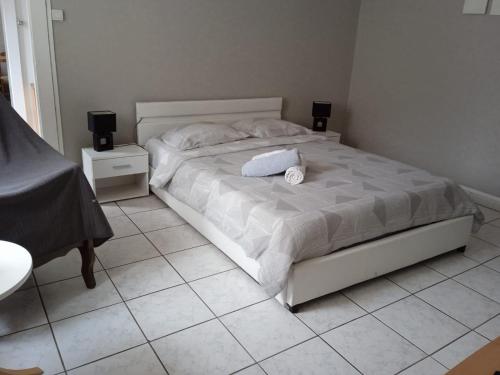 a bedroom with a white bed with two speakers at Meublés B-D in Bains-les-Bains