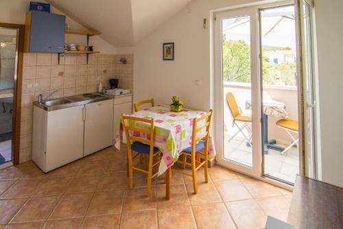 a small kitchen with a table and a balcony at Villa Tereza in Splitska