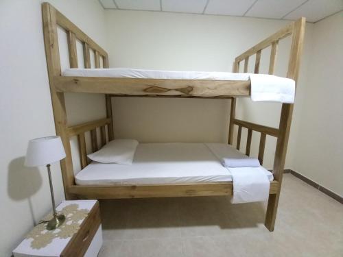 Ce lit se trouve dans un dortoir doté de 2 lits superposés et d'une lampe. dans l'établissement Ekolores Hostal 313-468-08-41, à Montenegro