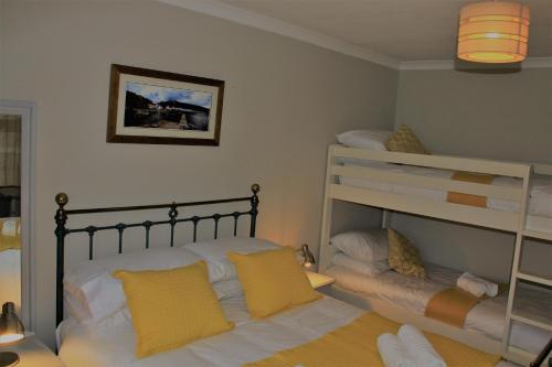a bedroom with two bunk beds and a bed at Bellevue Holiday Cottage in Gardenstown