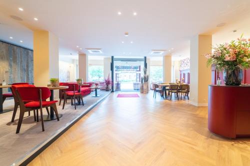 a lobby with tables and chairs and a cafeteria at Grand Hotel Normandy by CW Hotel Collection in Bruges