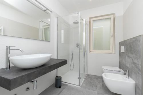 a bathroom with a sink and a shower and a toilet at Casa Prea Apartments in Malcesine