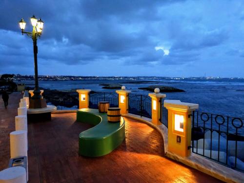 a balcony with a green bench and a view of the water at サンライン北谷コンドミニアムリゾート in Chatan