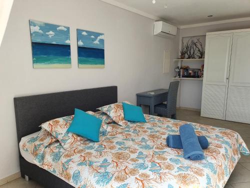 a bedroom with a bed with blue pillows on it at Den Laman - Balloonfish in Kralendijk