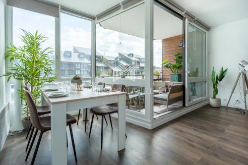 a dining room with a white table and chairs at Le Ponton C.L.S Deauville in Deauville