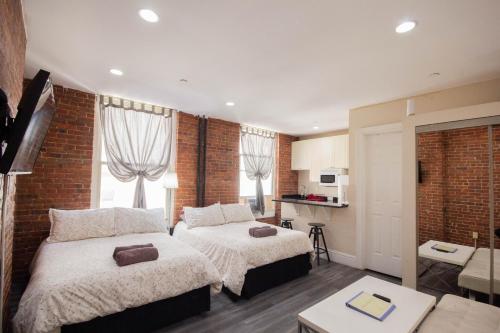 a hotel room with two beds and a kitchen at Studio Plus - Cozy Apartments in New York