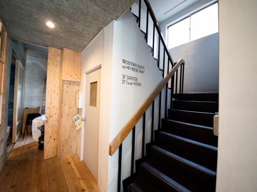 eine Treppe in einem Gebäude mit einem Schild an der Wand in der Unterkunft tune HIGORO in Tateyama