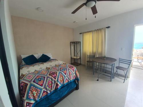 - une chambre avec un lit, une table et un ventilateur de plafond dans l'établissement Villa Bonita, à Isla Mujeres