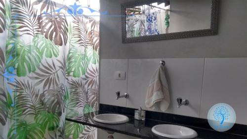 a bathroom with two sinks and a mirror at Camping Conforto Ypê Branco in Paraty