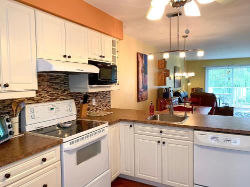 a kitchen with white cabinets and a counter top at Le Paréo de Magog-Mont Orford in Magog-Orford