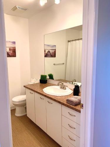 a bathroom with a sink and a toilet and a mirror at Le Paréo de Magog-Mont Orford in Magog-Orford