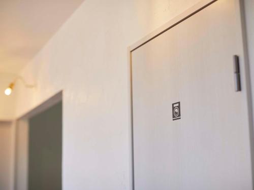 a door with a sign on it in a room at haku hostel in Shiraoi