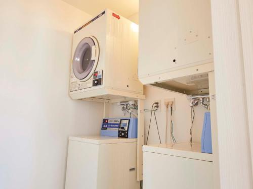 a laundry room with a dryer and a washing machine at haku hostel in Shiraoi