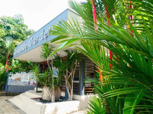 a store with palm trees in front of it at Cascade Gardens in Cairns
