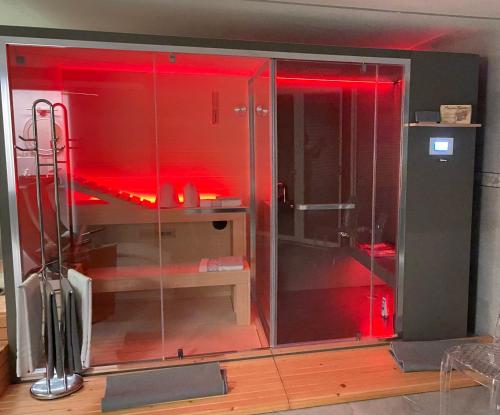 a glass shower with red lighting in a room at BALMA DEI CUP con SPA privata su richiesta in Pont Canavese