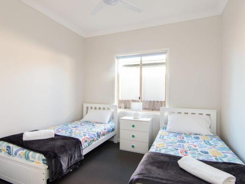 a bedroom with two beds and a window at 9 Breckenridge Street in Forster
