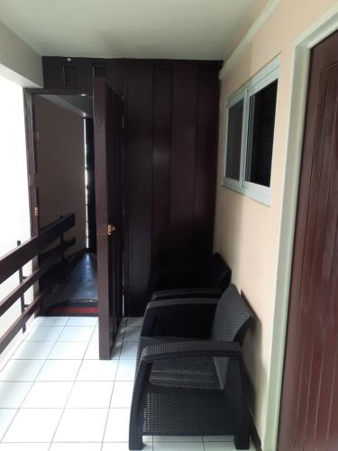 a hallway with two chairs and a door with a window at The Mango Lodge in Kingston