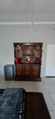 a living room with a wooden entertainment center at Sleepover @194 in Rustenburg