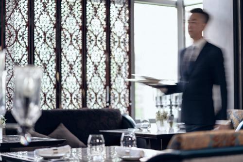 a man standing in front of a table in a restaurant at Four Seasons Hotel Beijing in Beijing