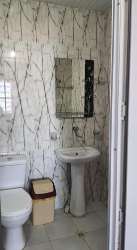 a bathroom with a white toilet and a sink at Ureki House in Ureki