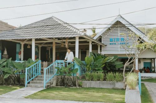 a woman standing on the porch of a house at Birru Inn in Kuta Lombok