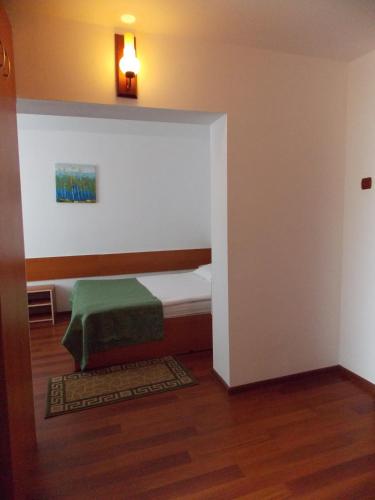a small bedroom with a bed with a green blanket at Hotel Amadeo in Iaşi