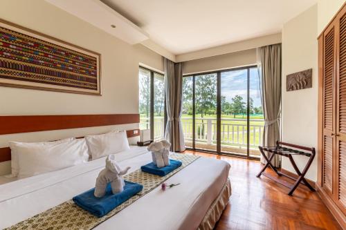 a bedroom with a bed and a large window at Allamanda Laguna Phuket by RESAVA in Bang Tao Beach