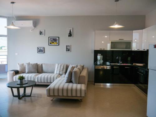 オリクムにあるNYC Modern & Spacious Apartament 5 min from seasideのリビングルーム(ソファ、テーブル付)、キッチンが備わります。
