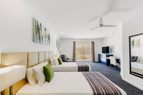 a bedroom with two beds and a living room at The Kimberley Grande Resort in Kununurra