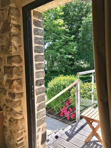 a window view of a deck with a bench at À L'orée Du Bois in Pommerit-le-Vicomte