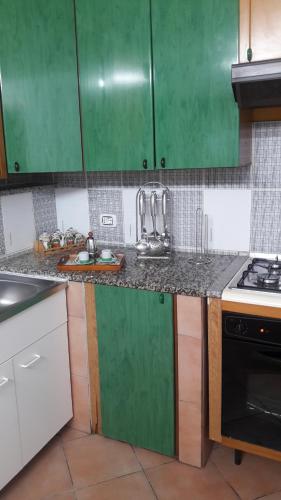 a kitchen with green cabinets and a counter top at Vendicari in Pachino