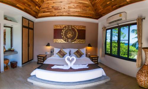 sypialnia z dużym łóżkiem i drewnianym sufitem w obiekcie Koh Tao Heights Pool Villas w Ko Tao