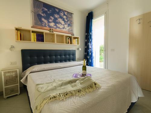 una camera da letto con un letto e una bottiglia di vino sopra di Borgo dei Fiori - relax and sea view with swimming pool a Magliolo