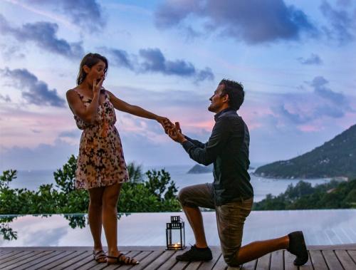 a man and a woman holding hands on a deck at Koh Tao Heights Pool Villas in Koh Tao