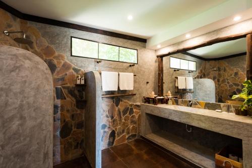 a stone bathroom with a sink and a mirror at Koh Tao Heights Pool Villas in Koh Tao