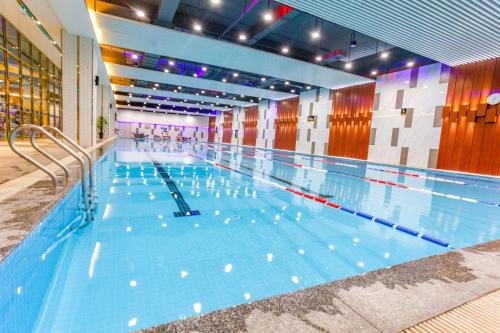 une grande piscine intérieure d'eau bleue dans l'établissement Ramada Foshan Nanhai, à Nanhai