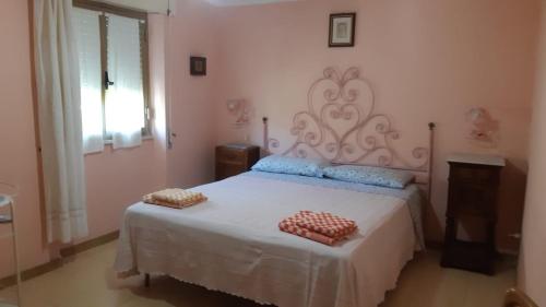 a bedroom with a white bed and a window at Casa Lucia Relax in Cala Gonone