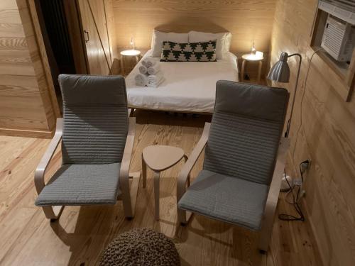 Cette petite chambre comprend un lit et deux chaises. dans l'établissement Little River Cabin, à Sparta