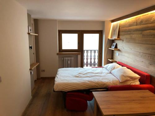 Un dormitorio con una cama y un sofá rojo. en Les Marmottes, en Breuil-Cervinia