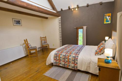 een slaapkamer met een bed en een tafel en stoelen bij Au Diapason Chambres d'hôtes montagne in Auzet