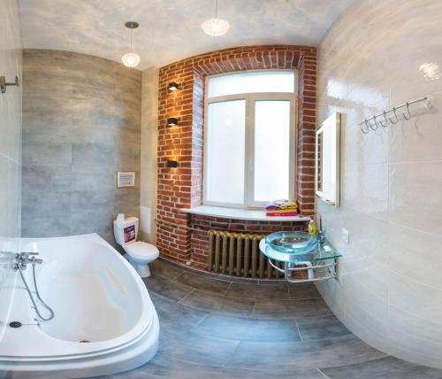 łazienka z wanną, umywalką i oknem w obiekcie Apartments in Kharkiv Center - Darvina str. 17/1 w Charkowie