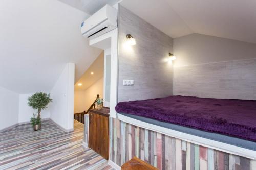 een slaapkamer met een paars bed in een kamer bij New apartments near the Constitution Square - Kuznechna str. 26/5 in Charkov