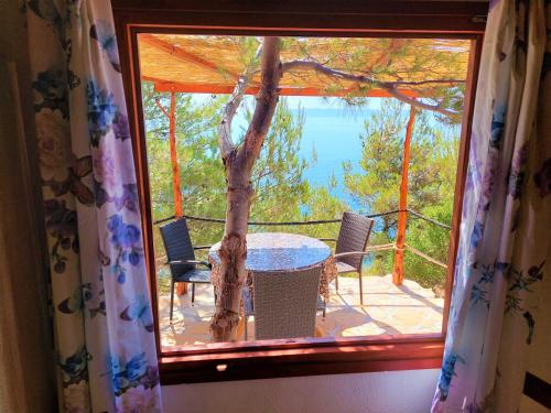 a window view of a table and chairs on a balcony at Vala Hrvaska Robinson in Gornji Humac