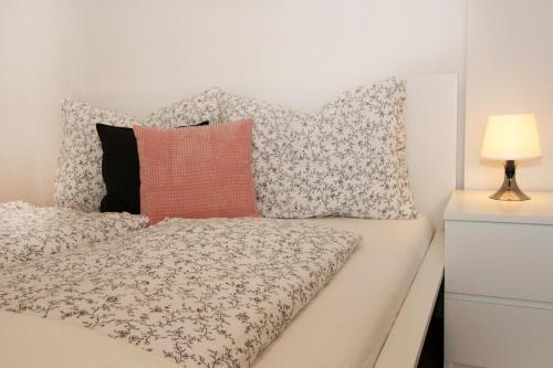 a bedroom with a bed with pillows and a lamp at Steira-Studios Leibnitz in Leibnitz
