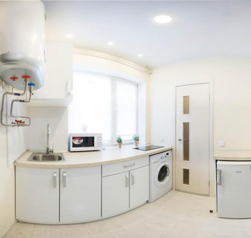 eine weiße Küche mit einer Spüle und einem Geschirrspüler in der Unterkunft New apartments in the city center - Kuznechna str. 26/1 in Kharkov